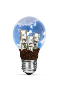 Light Bulb Growing Dollar Bills Reflecting Reduction In Utility Costs