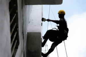 BidSource Commercial Painter Using Harness To Paint Building After Winning Commercial Painting Bids