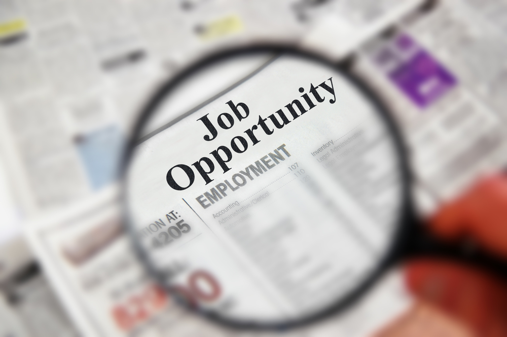 Job Opportunity in Newspaper under magnifying glass for Apartment Manager Jobs