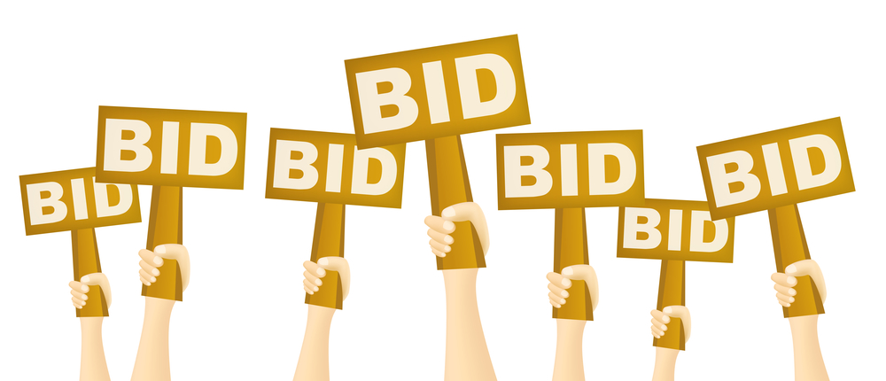 Hands Holding Bid Signs Up In The Air For BidSource Blog