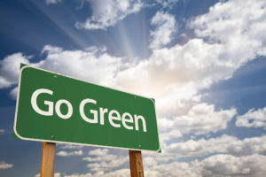Go Green on road sign with blue sky and sunshine for 9 Green Property Management Initiatives for 2019