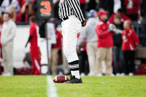 Football Resting On The Field WIth Referee