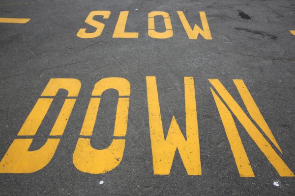 Slow Down Striped On Asphalt Roadway In Yellow Paint For Dealing With Speeders At Your Property