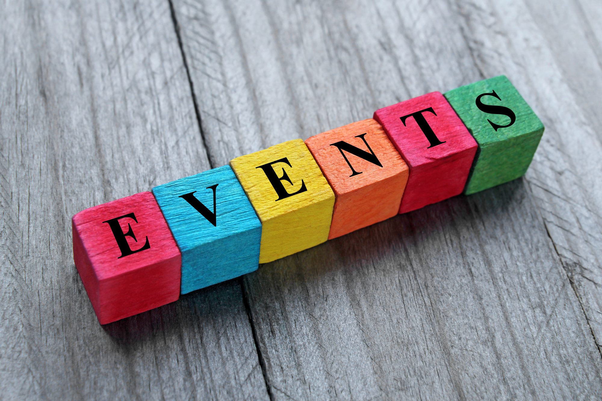 Events on block letters over wood background for The Ultimate List of Apartment Resident Event Ideas Blog