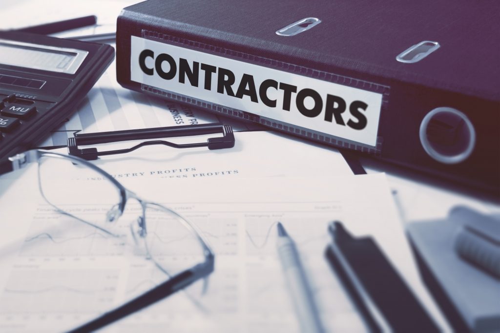 Approved Vendor Lists Inside Binder Labeled Contractors On Desk