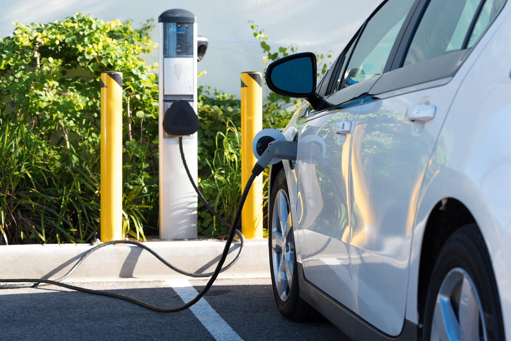 Electric Car Charging At EV Charging In Retail Parking Lot