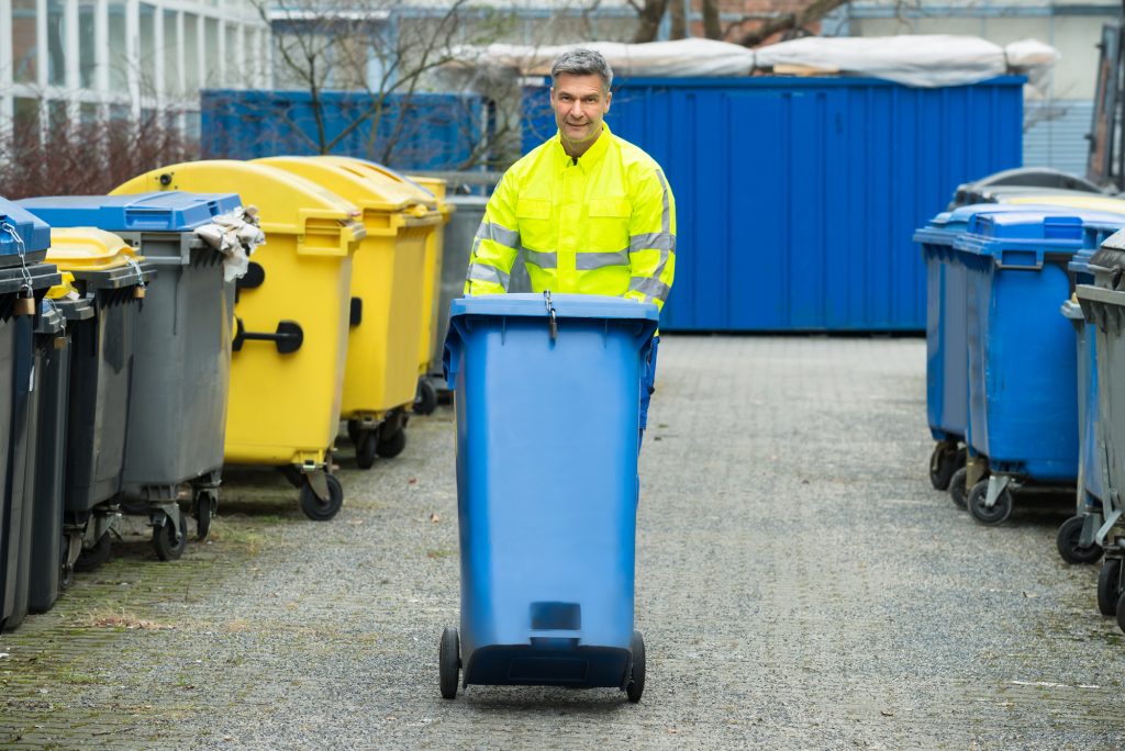 Valet Trash Company Employee Walking Bin In Dumpster Area For A Brief Overview of Valet Trash Services Blog