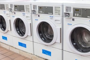 Stainless Steel Commercial Washing Machines With CoronaVirus In Multihousing Laundry Room