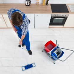 Man Cleaning Kitchen Floor In Rental Property For How To Clean Residential Rental Property Blog On Property Manager Insider