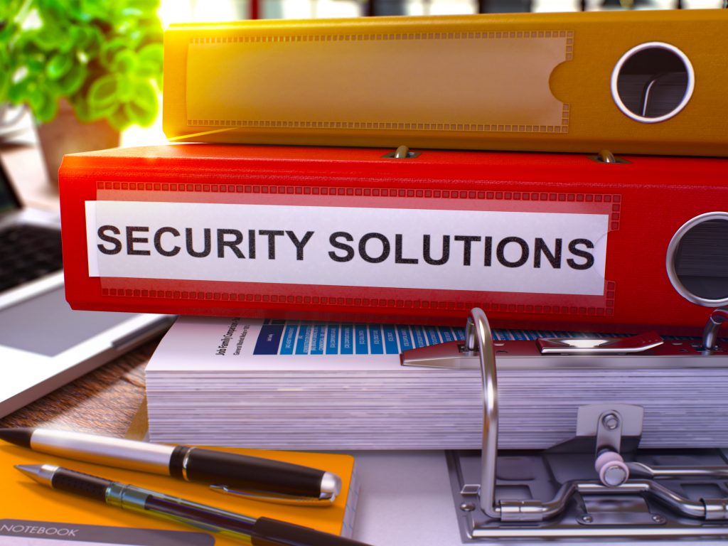 Security Solutions On Red Binder On Multifamily Property Manager's Desk