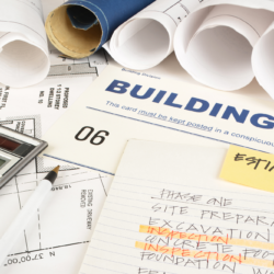 Commercial Construction Plans Permits And Estimates On Work Bench