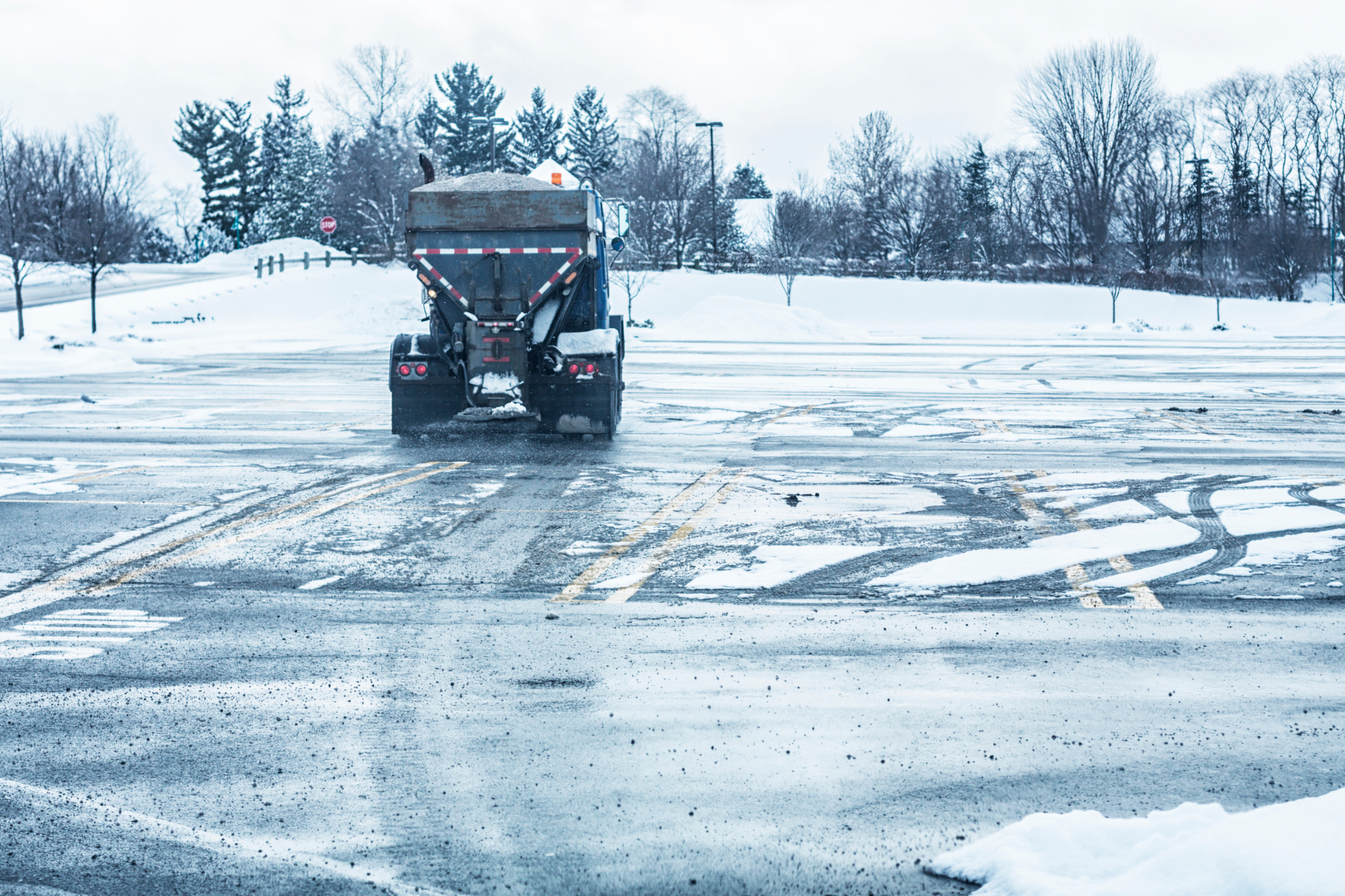 Commercial Truck Spread Salt To De-Ice Parking Lot After Winter Storm